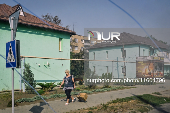 A woman walks along the street in the frontline city of Kurakhove, Pokrovsk district, Donetsk region, eastern Ukraine, on September 16, 2024...