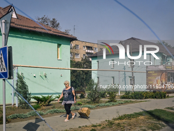 A woman walks along the street in the frontline city of Kurakhove, Pokrovsk district, Donetsk region, eastern Ukraine, on September 16, 2024...