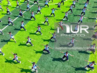 Primary school students practice martial arts during a class break in Tongren, China, on September 24, 2024. (