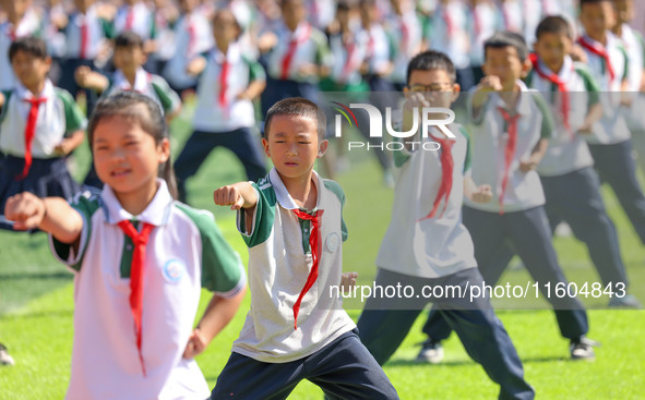 Primary school students practice martial arts during a class break in Tongren, China, on September 24, 2024. 