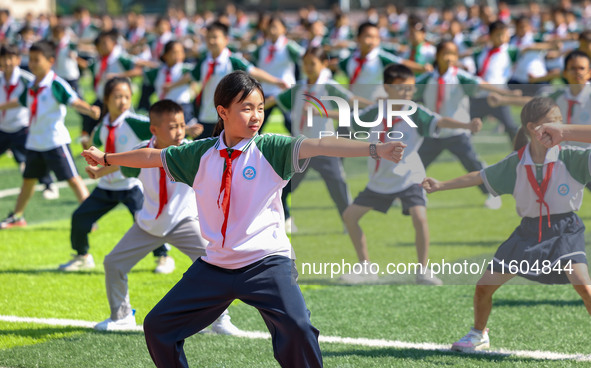 Primary school students practice martial arts during a class break in Tongren, China, on September 24, 2024. 