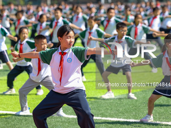 Primary school students practice martial arts during a class break in Tongren, China, on September 24, 2024. (