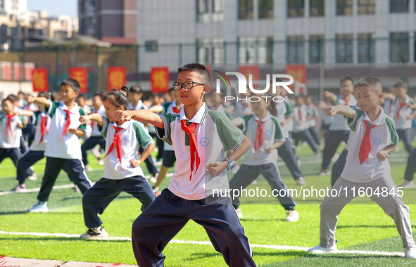 Primary school students practice martial arts during a class break in Tongren, China, on September 24, 2024. 