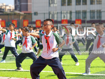 Primary school students practice martial arts during a class break in Tongren, China, on September 24, 2024. (