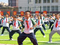 Primary school students practice martial arts during a class break in Tongren, China, on September 24, 2024. (