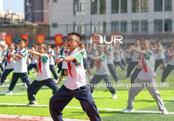 Primary school students practice martial arts during a class break in Tongren, China, on September 24, 2024. 