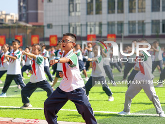 Primary school students practice martial arts during a class break in Tongren, China, on September 24, 2024. (