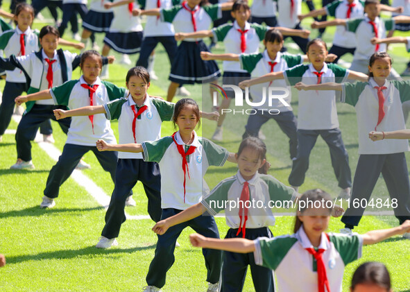 Primary school students practice martial arts during a class break in Tongren, China, on September 24, 2024. 