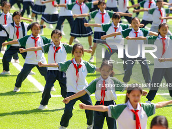 Primary school students practice martial arts during a class break in Tongren, China, on September 24, 2024. (