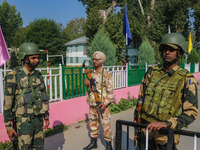 Indian security personnel stand guard as polling officials carry electronic voting machines (EVM) at a distribution center on the eve of the...