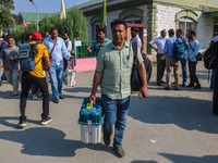 Polling officials carry electronic voting machines (EVM) at a distribution center in Srinagar, Jammu and Kashmir, on September 24, 2024, on...