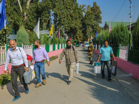 Polling officials carry electronic voting machines (EVM) at a distribution center in Srinagar, Jammu and Kashmir, on September 24, 2024, on...