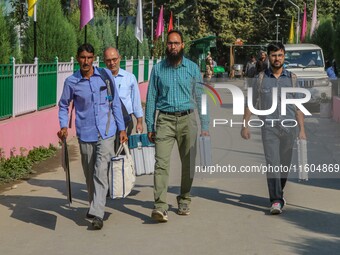 Polling officials carry electronic voting machines (EVM) at a distribution center in Srinagar, Jammu and Kashmir, on September 24, 2024, on...