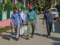 Polling officials carry electronic voting machines (EVM) at a distribution center in Srinagar, Jammu and Kashmir, on September 24, 2024, on...