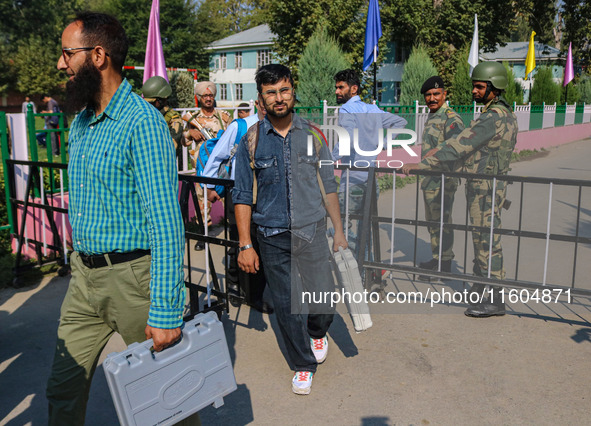 Polling officials carry electronic voting machines (EVM) at a distribution center in Srinagar, Jammu and Kashmir, on September 24, 2024, on...