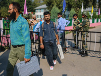 Polling officials carry electronic voting machines (EVM) at a distribution center in Srinagar, Jammu and Kashmir, on September 24, 2024, on...