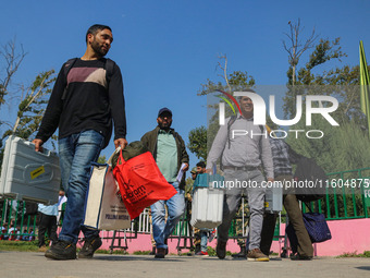 Polling officials carry electronic voting machines (EVM) at a distribution center in Srinagar, Jammu and Kashmir, on September 24, 2024, on...