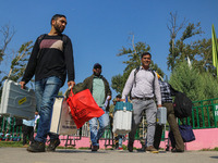 Polling officials carry electronic voting machines (EVM) at a distribution center in Srinagar, Jammu and Kashmir, on September 24, 2024, on...