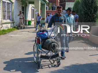 Polling officials carry electronic voting machines (EVM) at a distribution center in Srinagar, Jammu and Kashmir, on September 24, 2024, on...