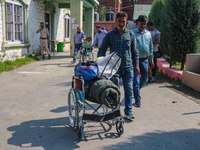 Polling officials carry electronic voting machines (EVM) at a distribution center in Srinagar, Jammu and Kashmir, on September 24, 2024, on...