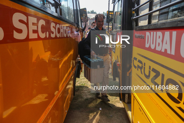 Polling officials carry electronic voting machines (EVM) at a distribution center in Srinagar, Jammu and Kashmir, on September 24, 2024, on...