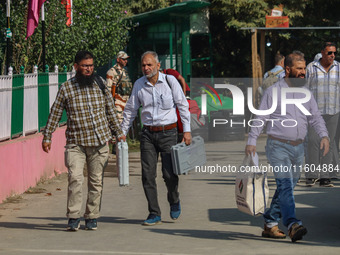 Polling officials carry electronic voting machines (EVM) at a distribution center in Srinagar, Jammu and Kashmir, on September 24, 2024, on...