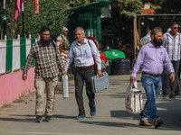 Polling officials carry electronic voting machines (EVM) at a distribution center in Srinagar, Jammu and Kashmir, on September 24, 2024, on...