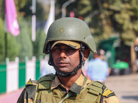 An Indian security personnel stands guard as polling officials carry electronic voting machines (EVM) at a distribution center on the eve of...