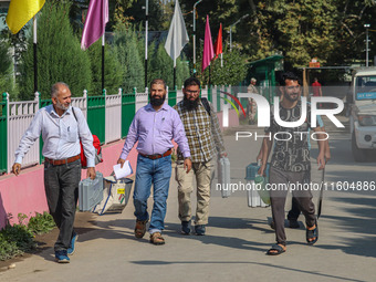 Polling officials carry electronic voting machines (EVM) at a distribution center in Srinagar, Jammu and Kashmir, on September 24, 2024, on...