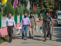 Polling officials carry electronic voting machines (EVM) at a distribution center in Srinagar, Jammu and Kashmir, on September 24, 2024, on...