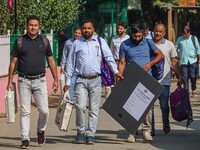 Polling officials carry electronic voting machines (EVM) at a distribution center in Srinagar, Jammu and Kashmir, on September 24, 2024, on...