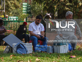 Polling officials sit beside electronic voting machines (EVM) at a distribution center on the eve of the second phase of voting during assem...