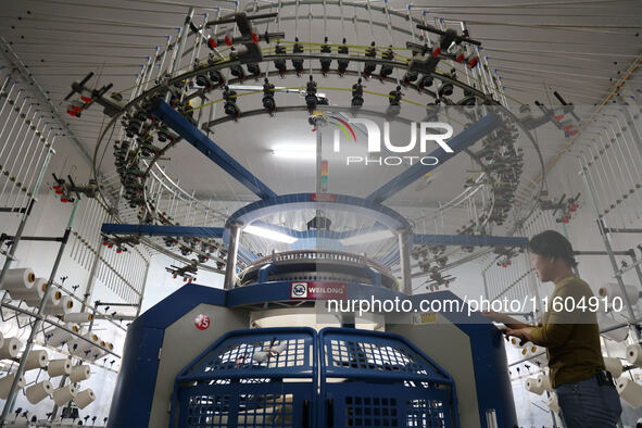 A worker produces products for export at a textile enterprise in Binzhou, China, on September 24, 2024. 