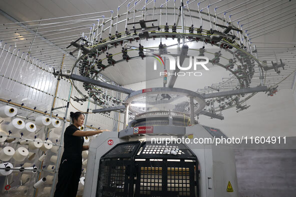 A worker produces products for export at a textile enterprise in Binzhou, China, on September 24, 2024. 