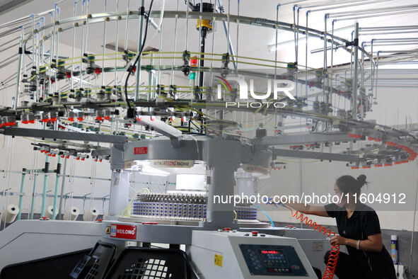 A worker produces products for export at a textile enterprise in Binzhou, China, on September 24, 2024. 