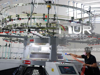 A worker produces products for export at a textile enterprise in Binzhou, China, on September 24, 2024. (