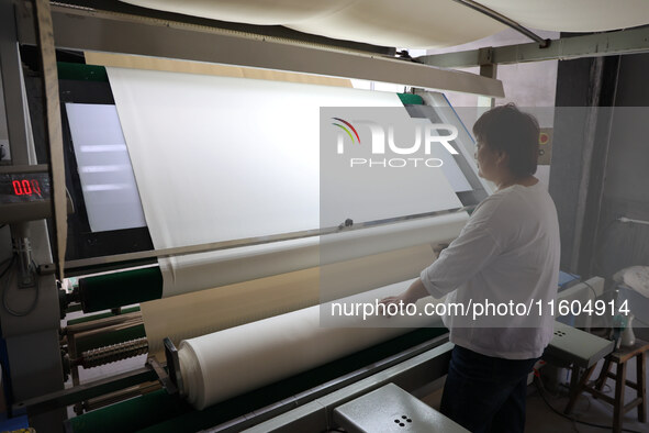 A worker produces products for export at a textile enterprise in Binzhou, China, on September 24, 2024. 