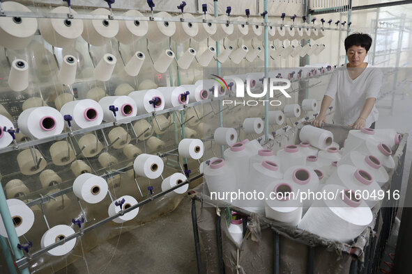 A worker produces products for export at a textile enterprise in Binzhou, China, on September 24, 2024. 