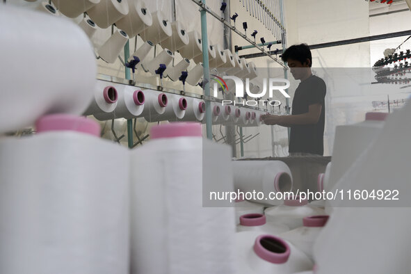 A worker produces products for export at a textile enterprise in Binzhou, China, on September 24, 2024. 