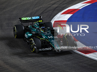 Fernando Alonso of the Aston Martin F1 Team AMR24 competes during the Formula 1 Singapore Grand Prix 2024 on the Marina Bay Circuit in Singa...