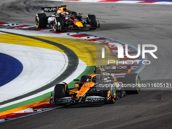 Lando Norris of McLaren F1 Team MCL38 and Max Verstappen of Red Bull Racing RB20 are in action during the Formula 1 Singapore Grand Prix 202...