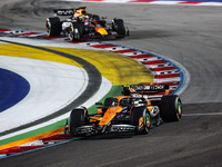 Lando Norris of McLaren F1 Team MCL38 and Max Verstappen of Red Bull Racing RB20 are in action during the Formula 1 Singapore Grand Prix 202...