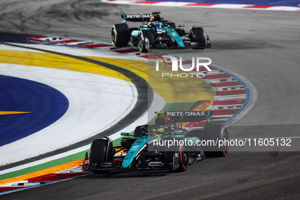 Lewis Hamilton of the Mercedes AMG F1 Team W15 and George Russell of the Mercedes AMG F1 Team W15 are in action during the Formula 1 Singapo...