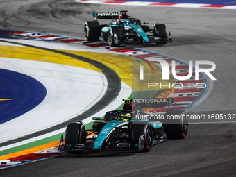 Lewis Hamilton of the Mercedes AMG F1 Team W15 and George Russell of the Mercedes AMG F1 Team W15 are in action during the Formula 1 Singapo...