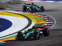 Lewis Hamilton of the Mercedes AMG F1 Team W15 and George Russell of the Mercedes AMG F1 Team W15 are in action during the Formula 1 Singapo...