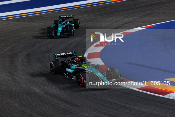 Lewis Hamilton of the Mercedes AMG F1 Team W15 and George Russell of the Mercedes AMG F1 Team W15 are in action during the Formula 1 Singapo...