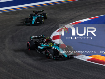 Lewis Hamilton of the Mercedes AMG F1 Team W15 and George Russell of the Mercedes AMG F1 Team W15 are in action during the Formula 1 Singapo...