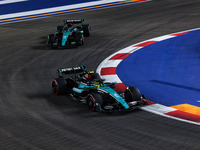 Lewis Hamilton of the Mercedes AMG F1 Team W15 and George Russell of the Mercedes AMG F1 Team W15 are in action during the Formula 1 Singapo...