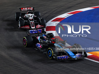 Esteban Ocon of Alpine F1 Team A524 and Kevin Magnussen of Haas F1 Team VF-24 Ferrari are in action during the Formula 1 Singapore Grand Pri...