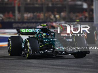 Fernando Alonso of the Aston Martin F1 Team AMR24 competes during the Formula 1 Singapore Grand Prix 2024 on the Marina Bay Circuit in Singa...